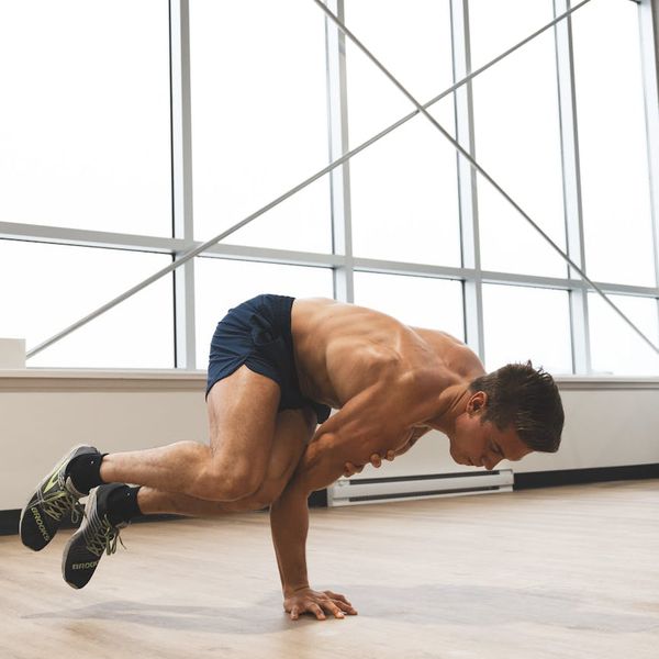 Man performing a controlled strength exercise in a modern gym.